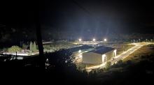Parque fotovoltaico con tres potentes reflectores que iluminan la montaña